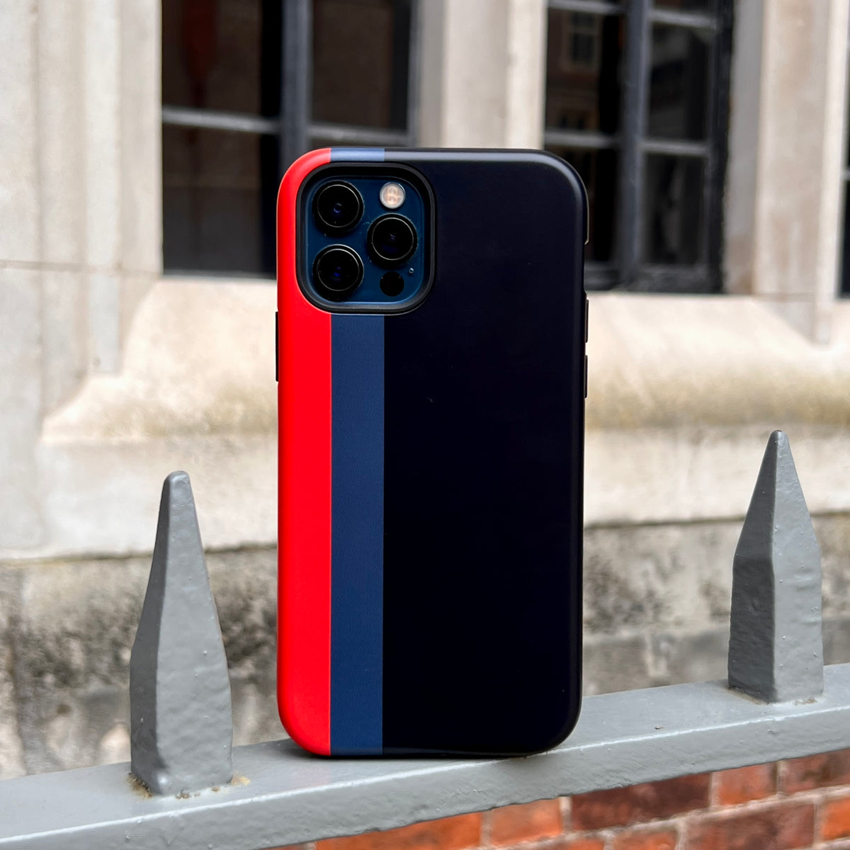 iPhone Tough Case in Chapel design featuring a black, navy, and red vertical stripe pattern on a durable dual-layer shell.