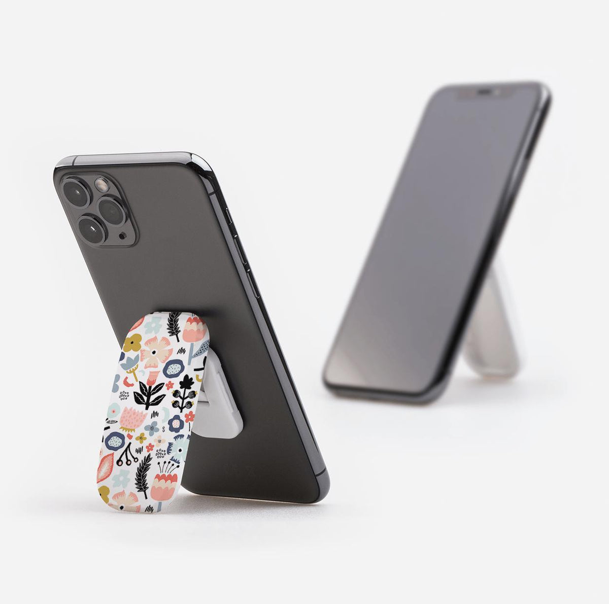 Aarhus phone stand with a colorful floral pattern attached to the back of a smartphone, acting as a prop-up kickstand.