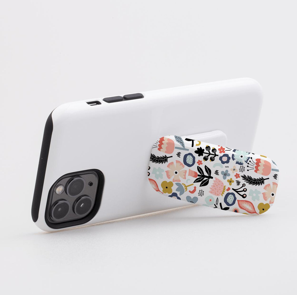 Aarhus phone stand with a colorful floral pattern attached to the back of a white smartphone case.