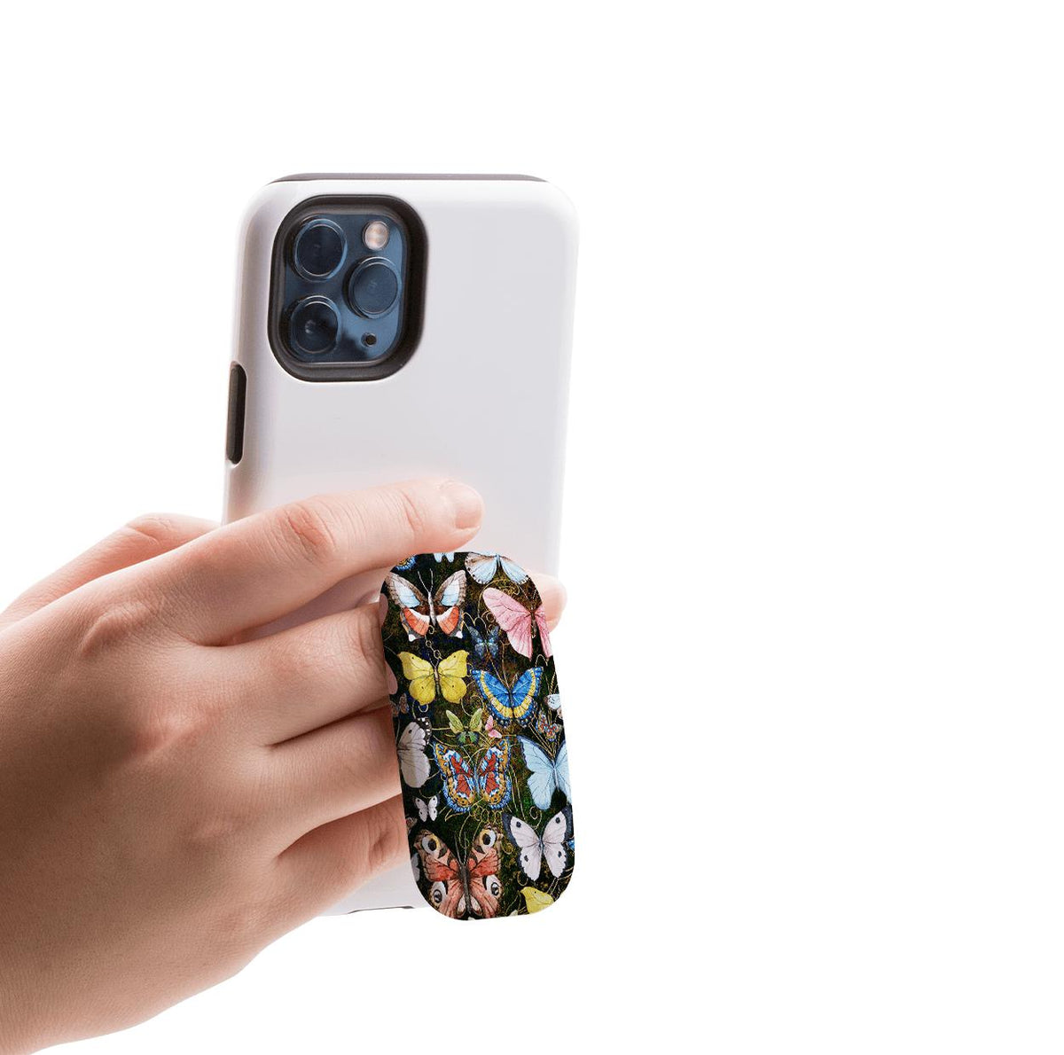 Hand holding a white smartphone with an oval butterfly-patterned Clickit phone stand attached to the back.