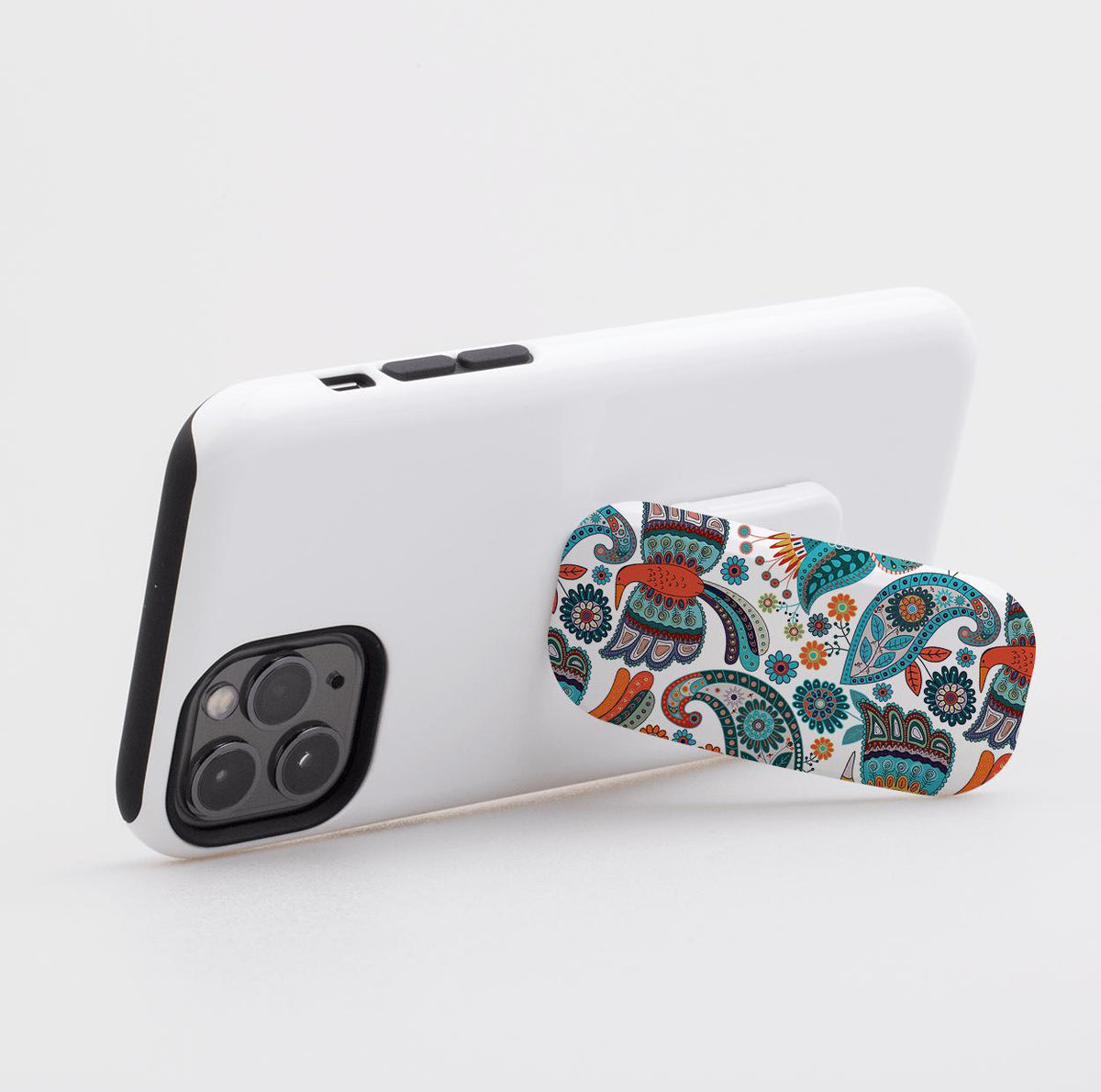 Avoch phone stand with a colorful paisley and floral pattern attached to the back of a white smartphone case.