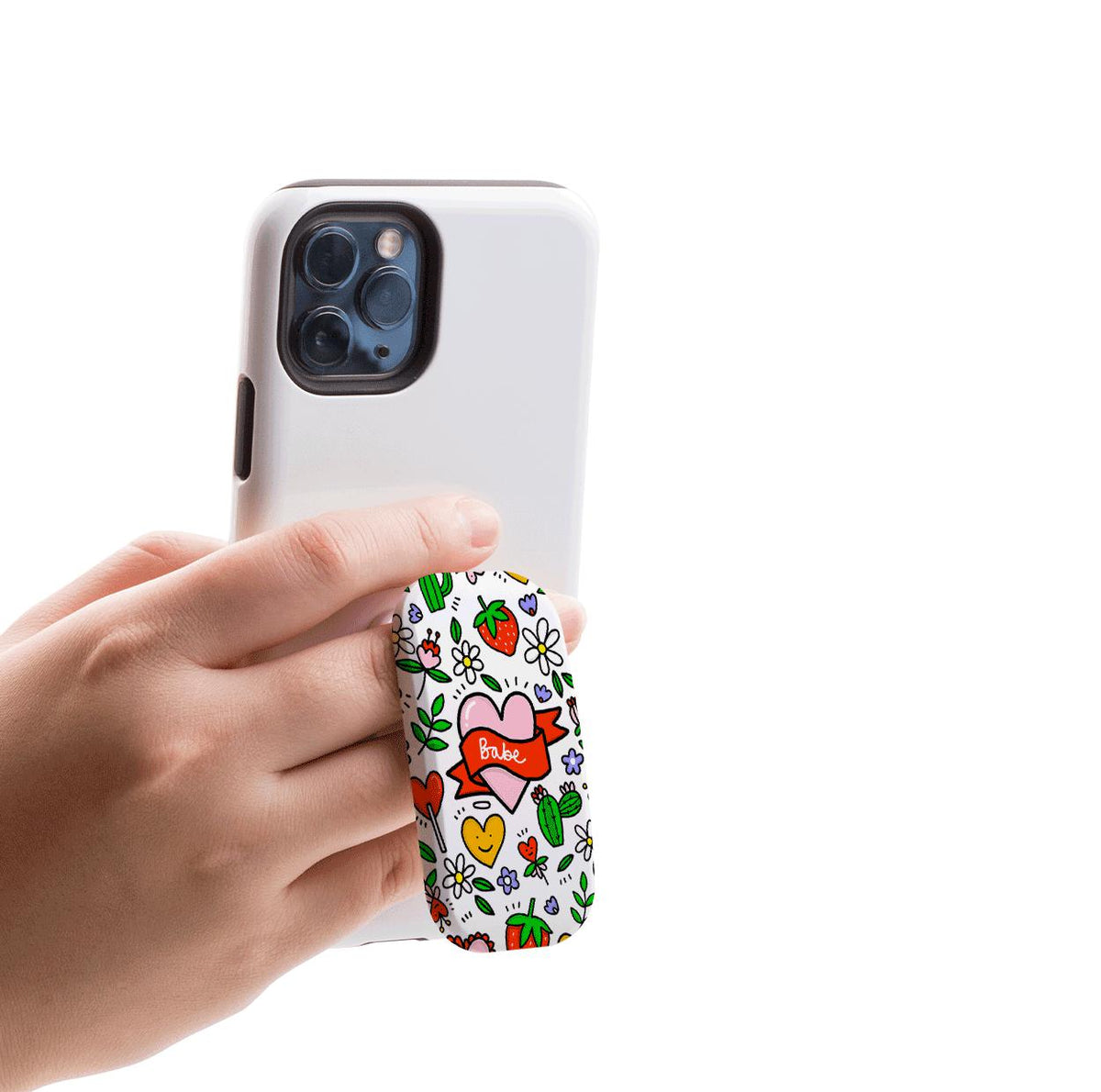 Hand holding a white phone with a Babe-themed Flickit stand featuring colorful heart, strawberry, and flower illustrations.