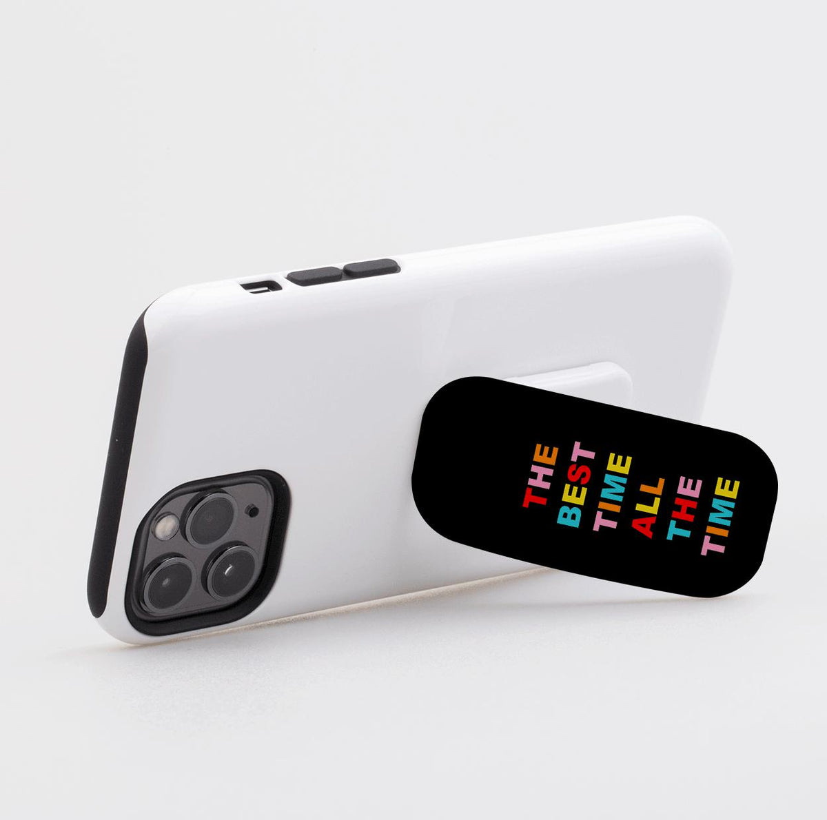 Black Flickit phone stand on a white smartphone with colorful text reading The Best Time All The Time.