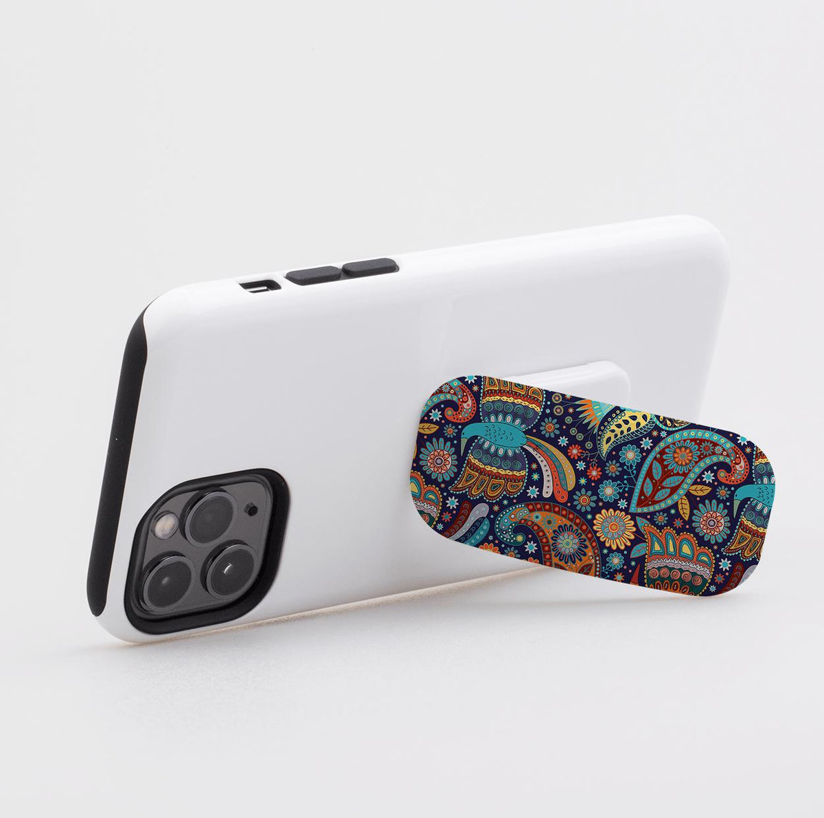 Bettyhill phone stand with a colorful, intricate paisley pattern attached to the back of a white smartphone.
