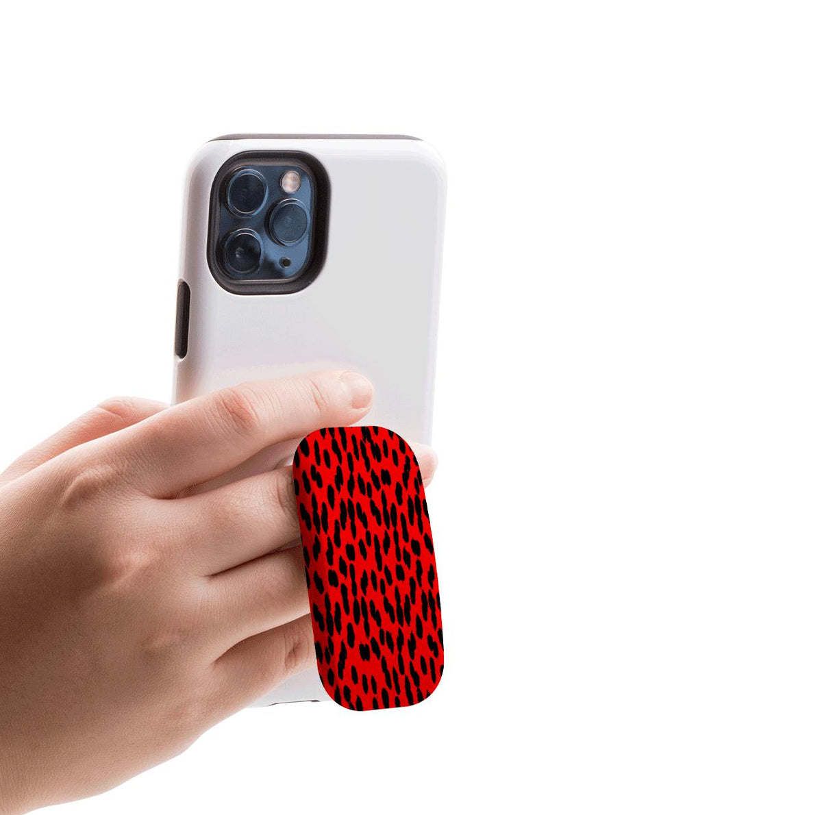 Hand holding a white smartphone with a red and black animal print Flickit phone stand attached to the back.