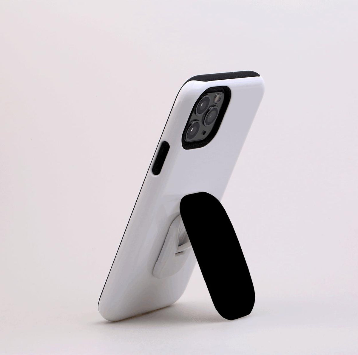 Black Flickit phone stand attached to a white smartphone, propped up in a landscape viewing position.