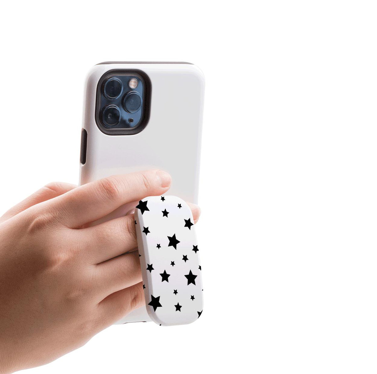 Hand holding a white smartphone with a black star-patterned Flickit phone stand attached for a secure grip.