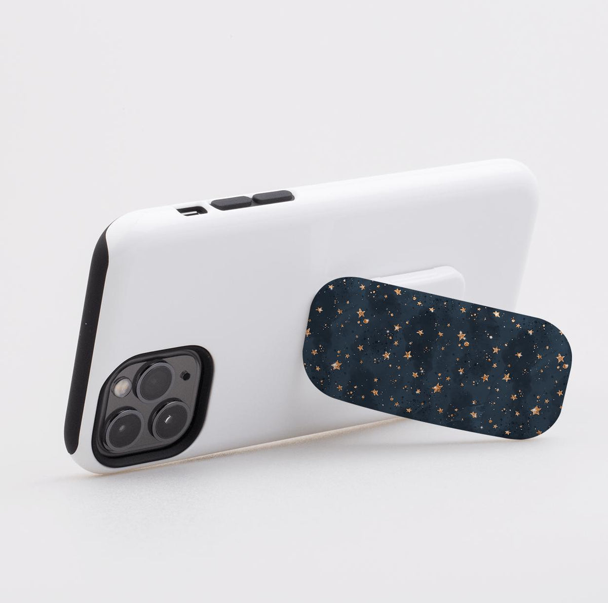 Bode Galaxy phone stand with a navy blue starry pattern attached to the back of a white smartphone case.