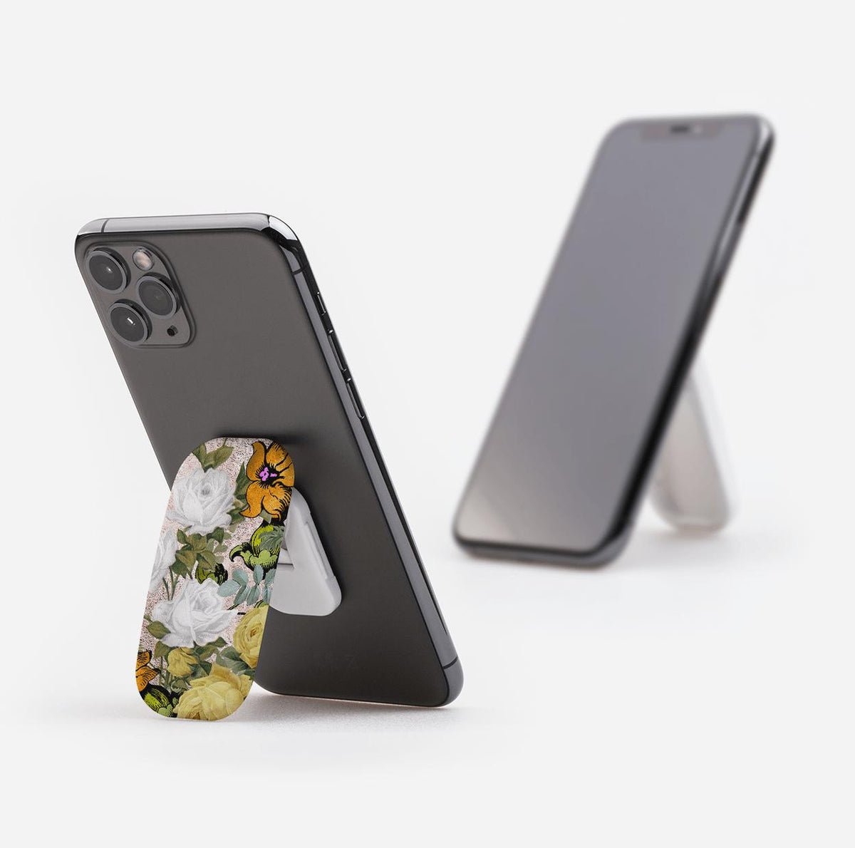 Oval Bowes phone stand with a vintage floral print attached to the back of a smartphone, acting as a kickstand.