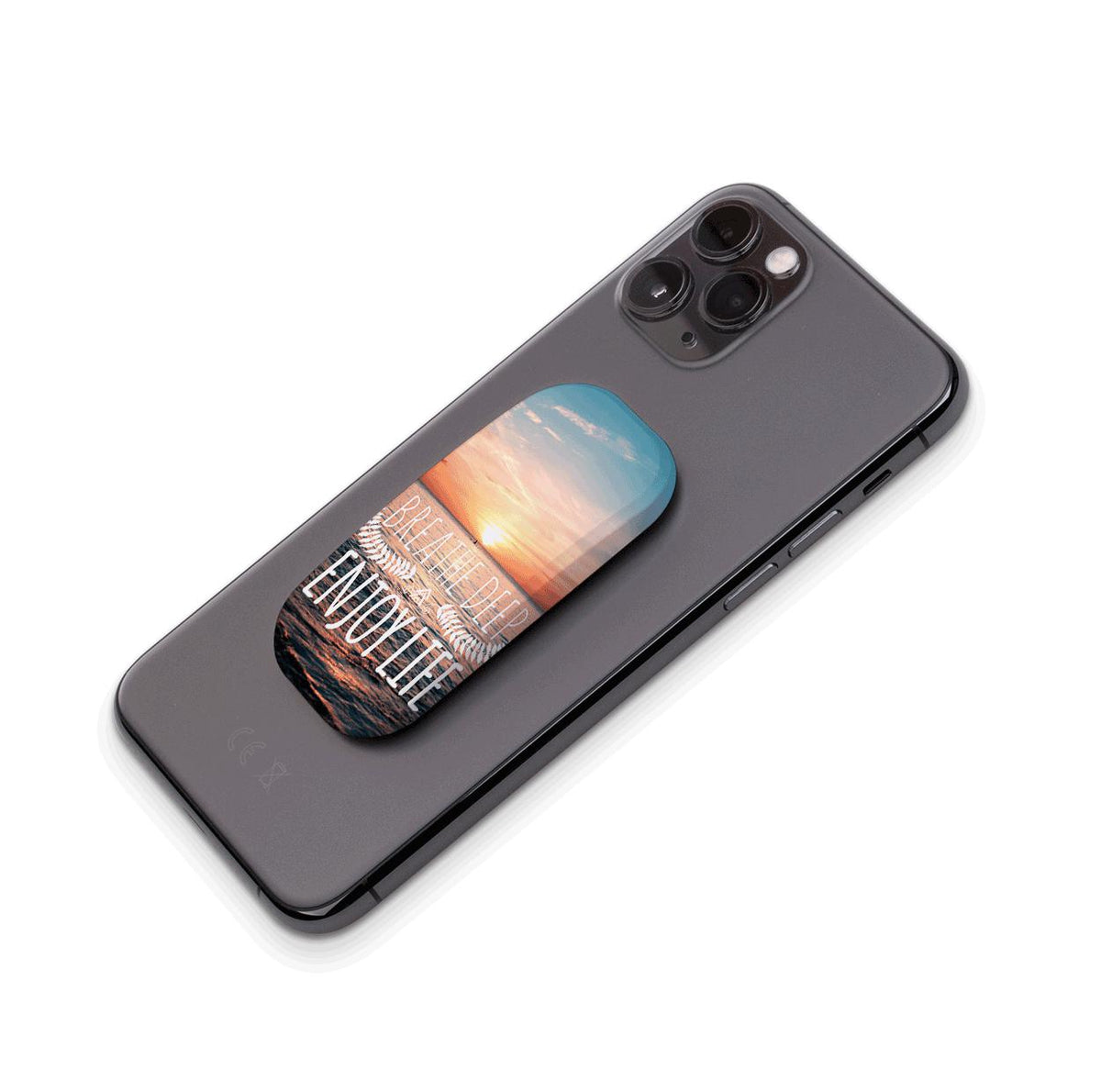 Breathe Deep Flickit phone stand attached to a black smartphone, featuring a sunset ocean scene with inspirational text.