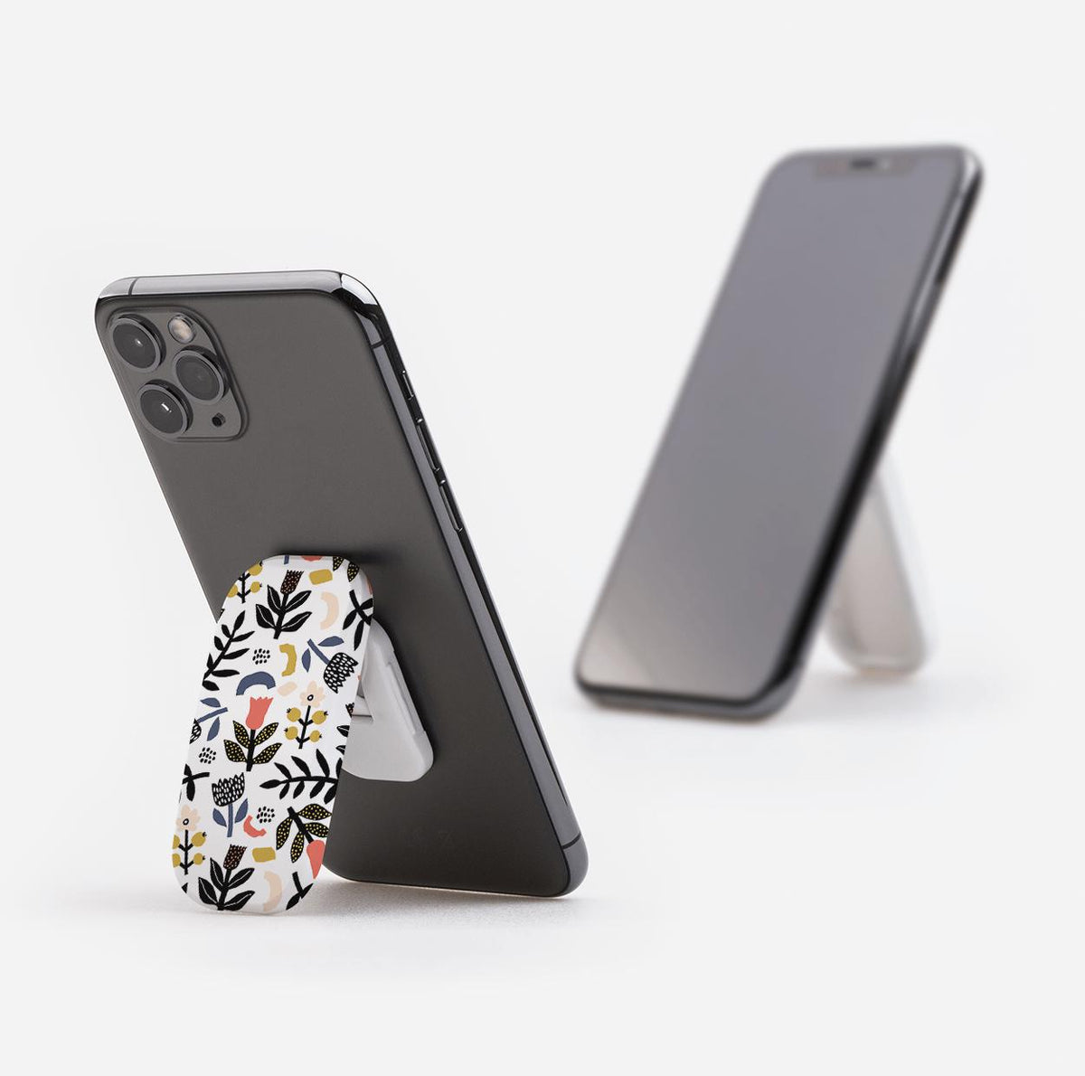 Broad Oak Clickit phone stand with a floral botanical pattern, attached to a black smartphone acting as a kickstand.