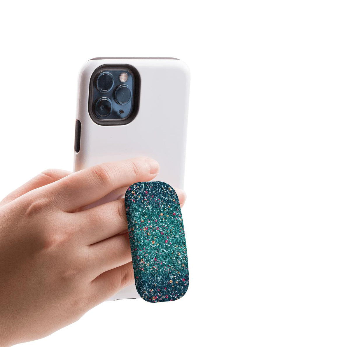 Hand holding a white smartphone with a teal, speckled Butterfly Comet Clickit phone stand attached to the back.