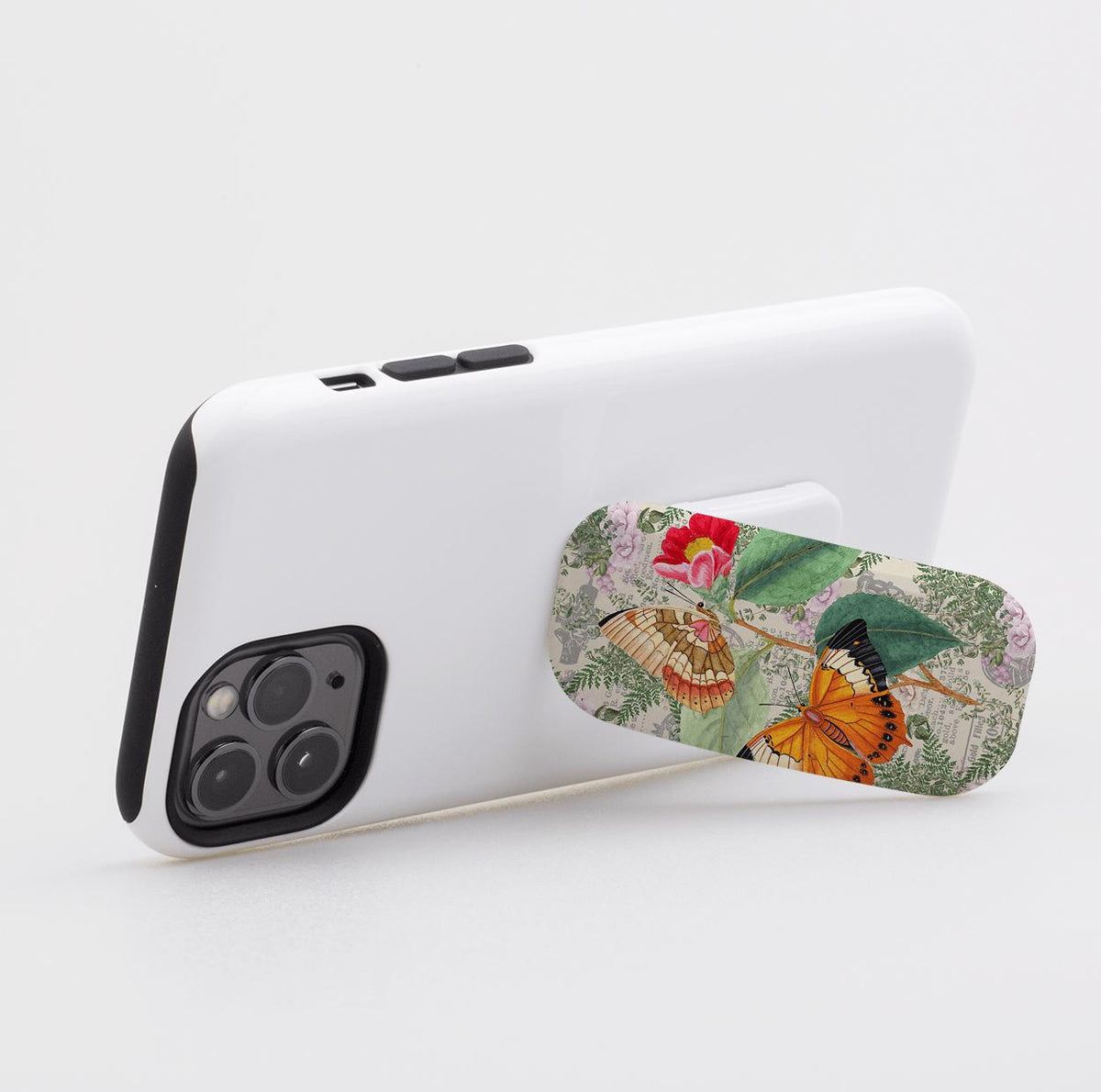 Butterfly Stories Clickit Handyhalter mit einem vintage botanischen Schmetterlingsdruck, befestigt an einer weißen Smartphone-Hülle