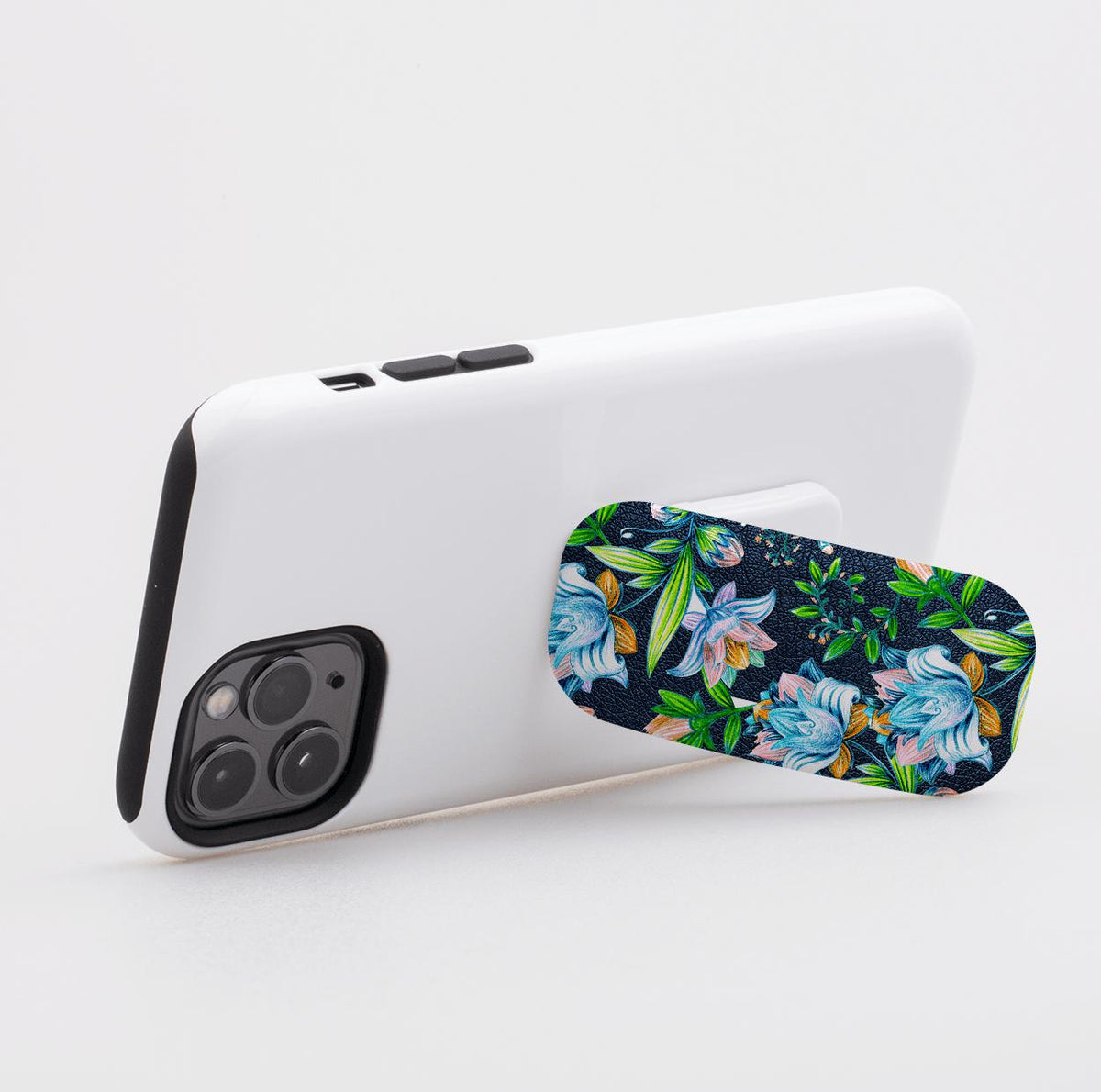 Chester phone stand with a dark blue floral pattern attached to the back of a white smartphone case.