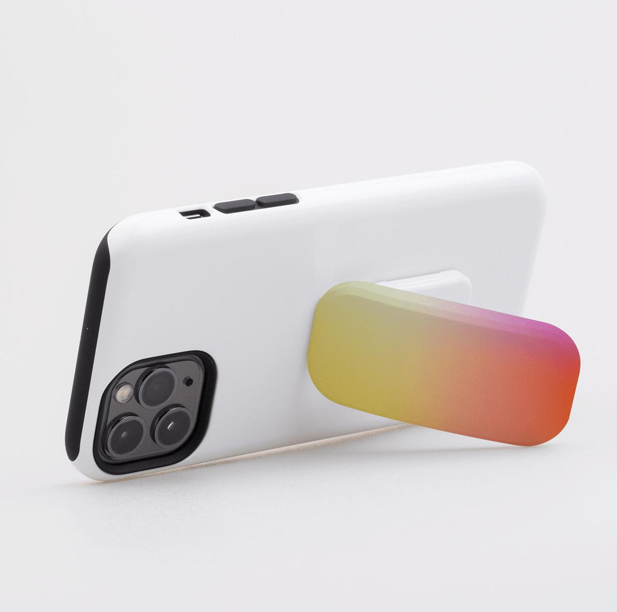 Rectangular gradient phone stand in yellow, orange, and pink attached to the back of a white smartphone case.