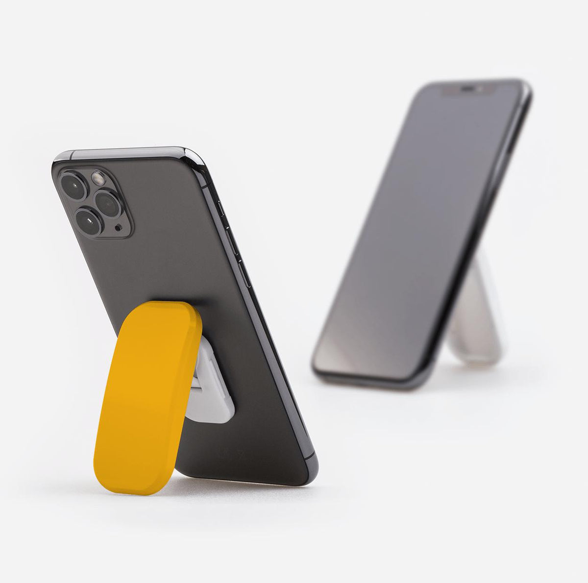 Yellow Honey phone stand attached to the back of a smartphone, propping it up in portrait mode on a white background.