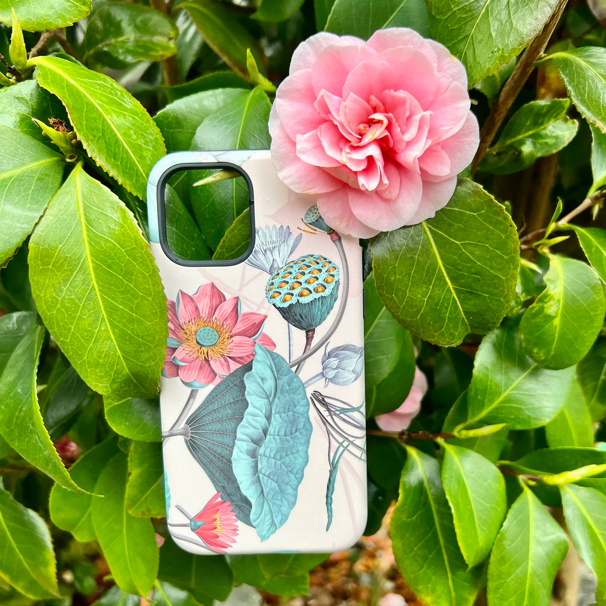 Finchcocks iPhone tough case featuring a botanical lotus flower print, resting among lush green leaves and a pink camellia.