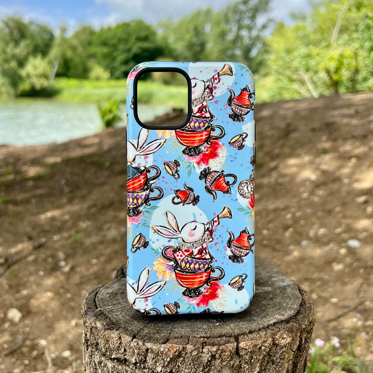 iPhone tough case with a whimsical Tea Party print featuring rabbits and teapots on a light blue background.