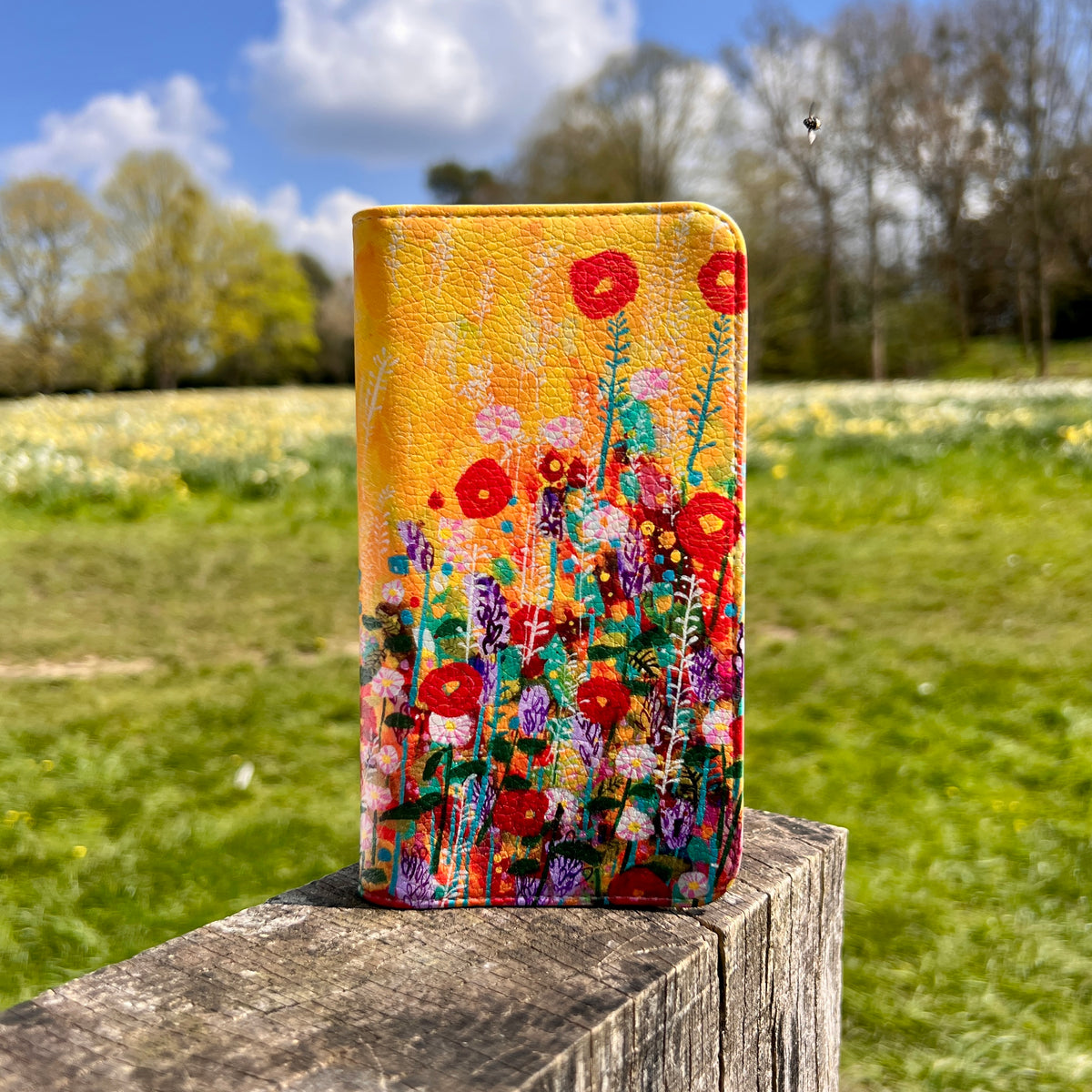 Vegan leather folio phone case featuring vibrant Summer Meadow floral artwork with a smooth satin finish.