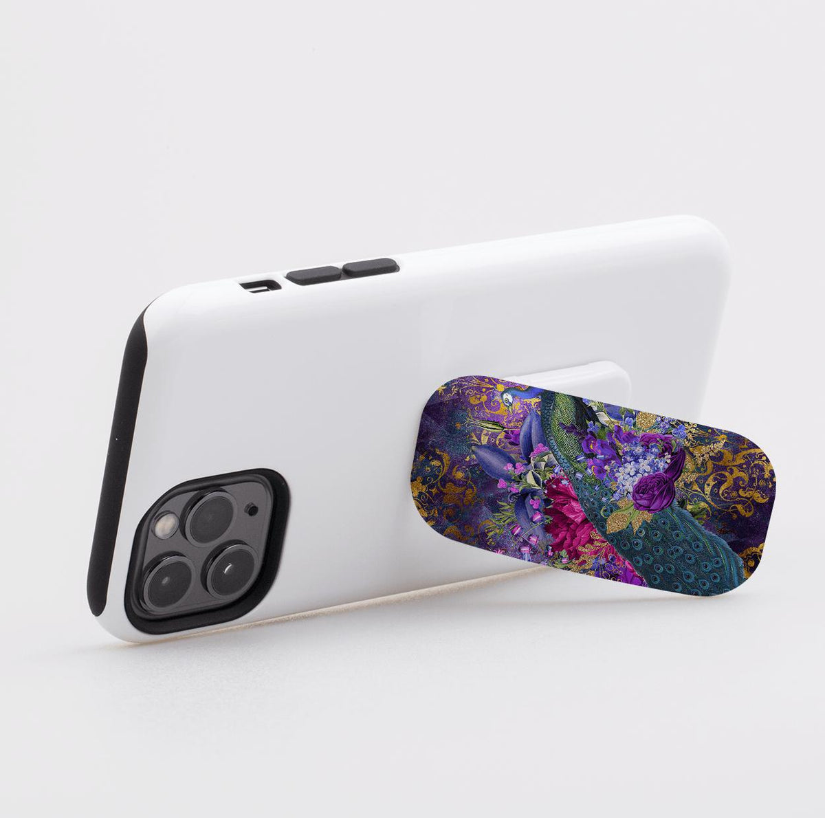 Wonders phone stand with a vibrant peacock and floral print attached to the back of a white smartphone.